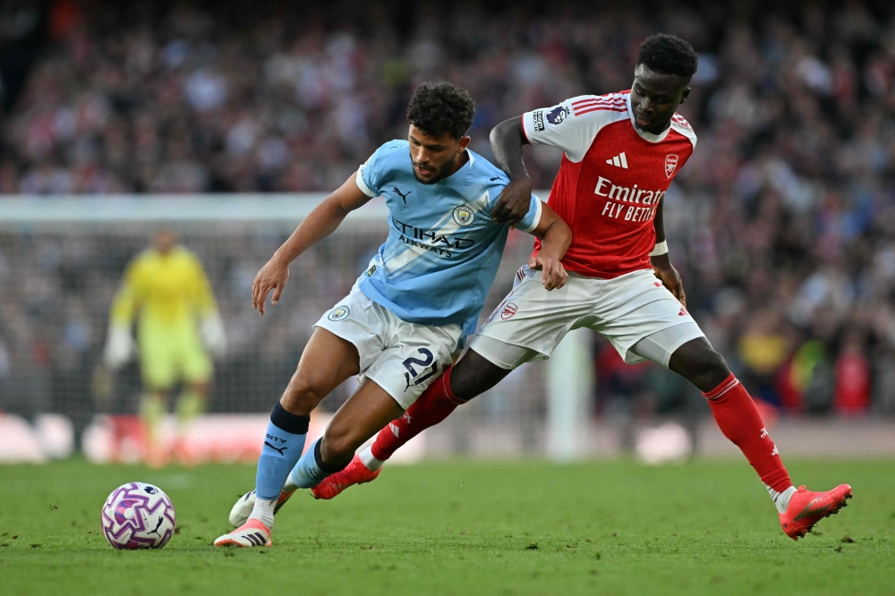 Manchester City’s Portuguese midfielder #27 Matheus Nunes (left) vies with Arsenal’s English midfielder #07 Bukayo Saka (right) during the English Premier League football match between Arsenal and Manchester City at the Emirates Stadium in London September 21, 2025. — AFP pic