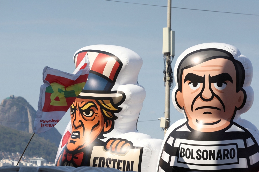 Inflatable figures depicting Brazil's former President Jair Bolsonaro and US President Donald Trump are seen during a protest against PEC 3/2021, known as the 'PEC da Blindagem' (Shield PEC), approved this week by Congress, and against a proposed Amnesty Bill that would change penalties for those convicted of plotting a coup, set for a vote next week, at Copacabana beach in Rio de Janeiro September 21, 2025. — Reuters pic  