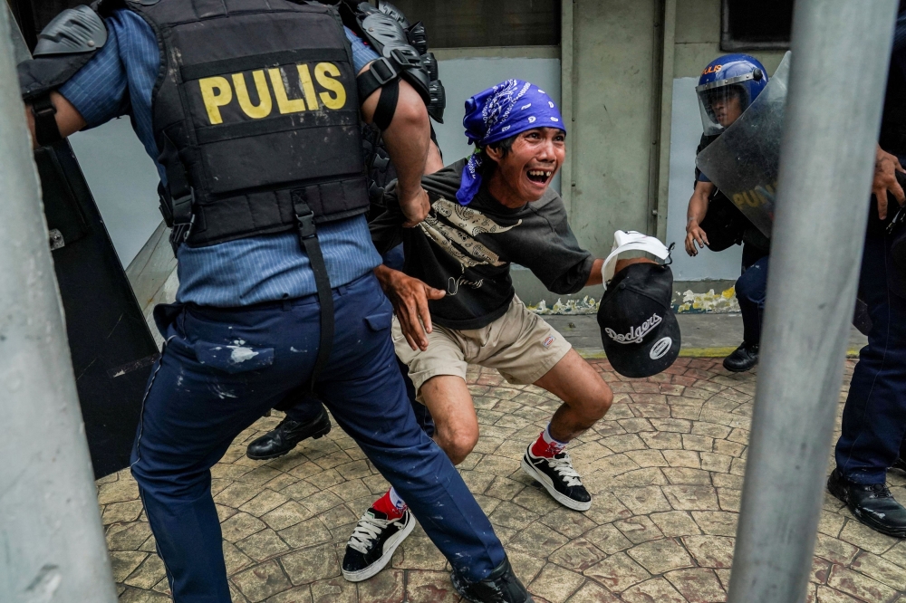 Police officers detain a protester during a protest denouncing what they call corruption linked to flood control projects, in Manila September 21, 2025. — Reuters pic 