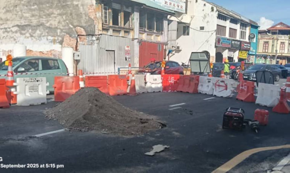 Work to repair the sinkhole at the junction of Burmah Road and Macalister Lane in George Town is ongoing. — Picture from Facebook/MBPP