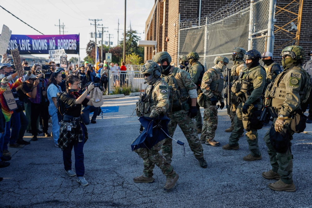 Law enforcement officers face pro-immigration demonstrators during a protest outside an ICE processing center in Broadview, Illinois, on September 19, 2025. — AFP pic