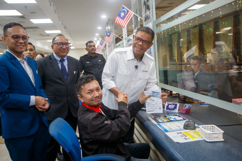 Datuk Seri Saifuddin Nasution Ismail, Home Minister, interacts with a member of the public during his visit to the National Registration Department in Putrajaya September 23, 2025. — Picture by Raymond Manuel