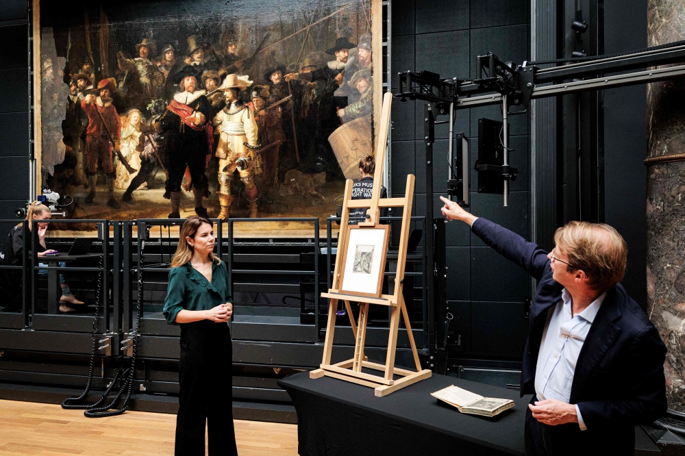 Rijksmuseum curator Anne Lenders (left) and director Taco Dibbits present their discovery concerning the dog in Rembrandt's ‘The Night Watch’ painting, in Amsterdam September 23, 2025. — AFP pic
