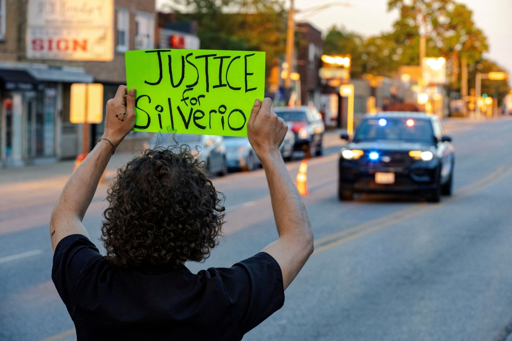 An activist blocks the street near a memorial for Silverio Villegas-Gonzalez who was shot and killed by federal agents during a traffic stop, after US President Donald Trump ordered increased federal law enforcement presence to assist in crime prevention, in Franklin Park, Illinois September 15, 2025. — Reuters pic  