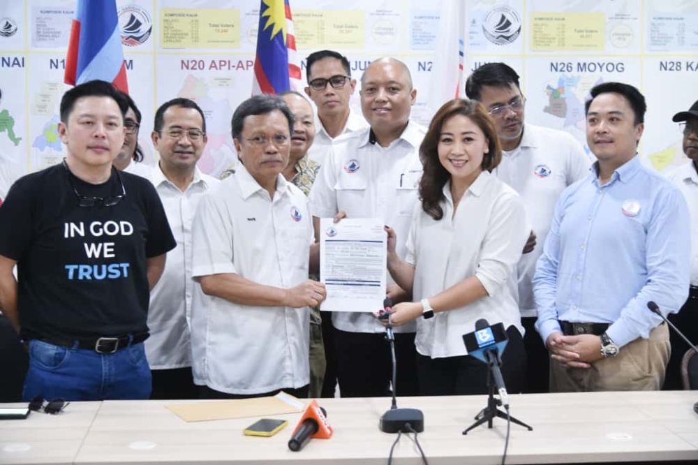 Edna Majimbun (second from right) hands over her application to Warisan president Datuk Seri Shafie Apdal. — Picture courtesy of Parti Warisan