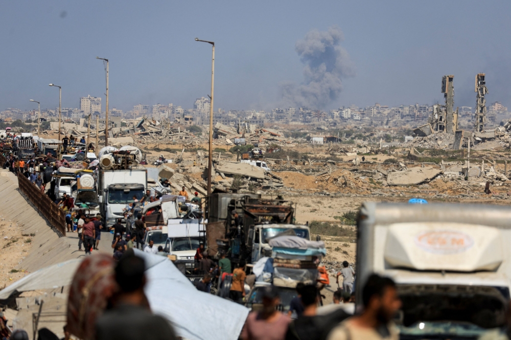 Smoke rises from an Israeli strike, as displaced Palestinians, fleeing northern Gaza due to an Israeli military operation, move southward after Israeli forces ordered residents of Gaza City to evacuate to the south, in the central Gaza Strip September 24, 2025. — Reuters pic 