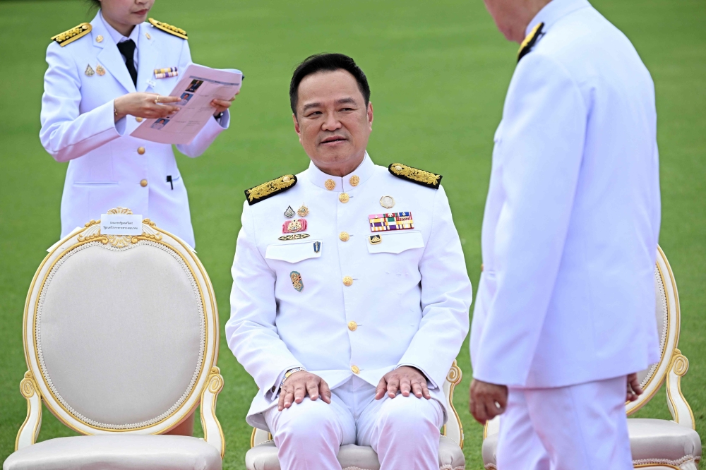 Thailand’s Prime Minister Anutin Charnvirakul sits for an official photo with members of the new cabinet, before they are sworn in to office, at Government House in Bangkok on September 24, 2025. — AFP pic