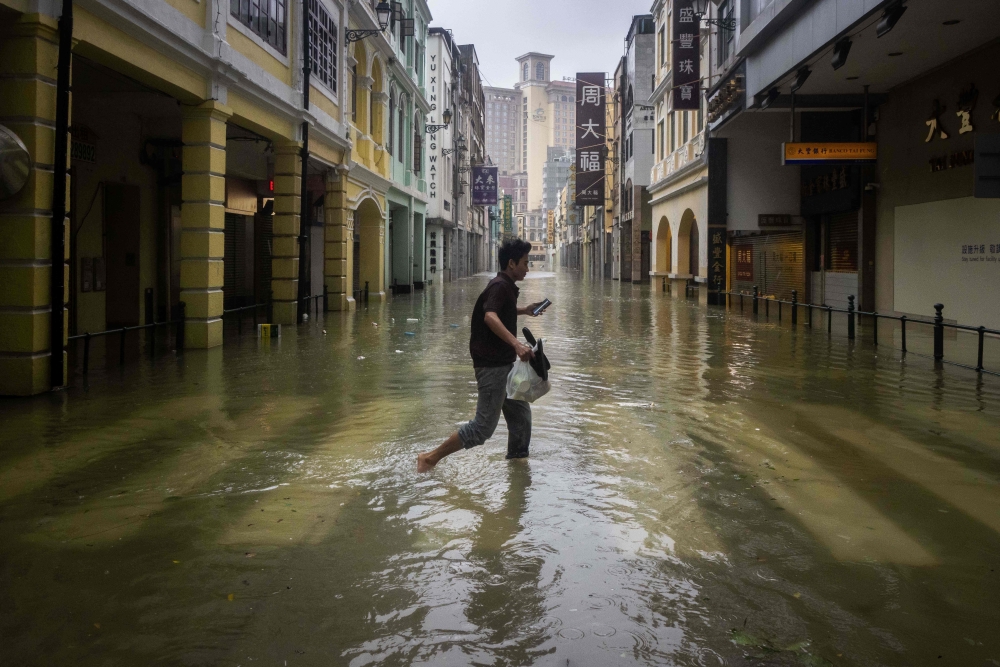 A pedestrian crosses the flooded San Ma Lo commercial area during the passage of Super Typhoon Ragasa in Macau September 24, 2025. — AFP pic