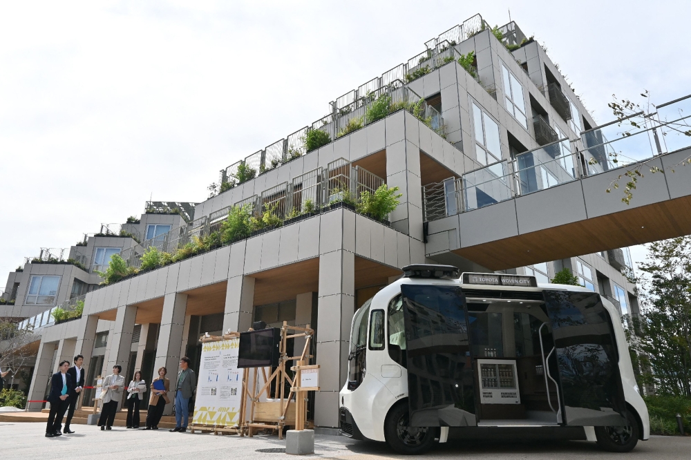 The courtyard of Toyota Motor Corporation's ‘Woven City’ and the self-driving electric vehicle (EV) ‘e-Palette’ (right) are pictured in the city of Susono, Shizuoka Prefecture September 25, 2025. — AFP pic