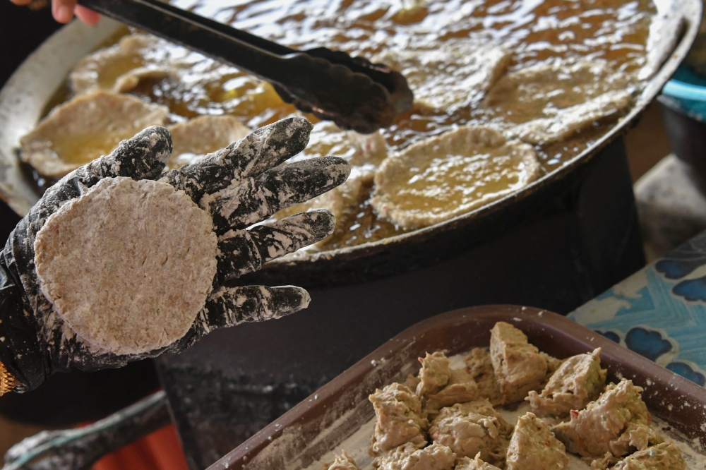 A worker shapes Keropok Laila at Kuala Besar Jetty in Kota Bharu September 26, 2025. — Bernama pic