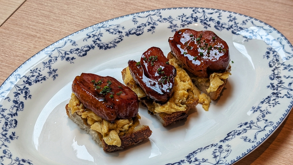 Bacon and eggs, but make it a thick slab of duck bacon glazed with honey. — Picture by Ethan Lau