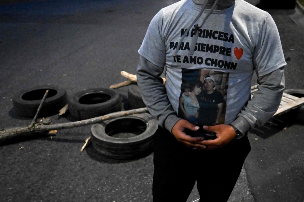 A man wears a shirt with the image of one of the three young women murdered in Argentina, next to a barricade in the La Tablada neighborhood, on the outskirts of Buenos Aires September 26, 2025. — AFP pic