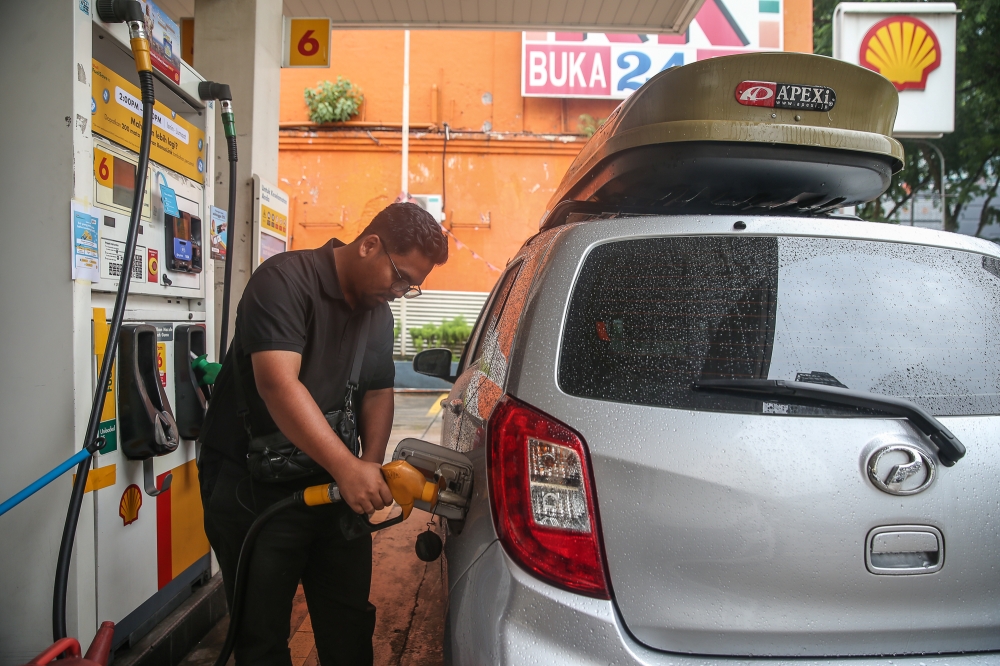 STR recipient Muhammad Nikhwan Idrus filling up his car under the new Budi Madani RON95 (BUDI95) initiative programme. — Picture by Yusof Isa