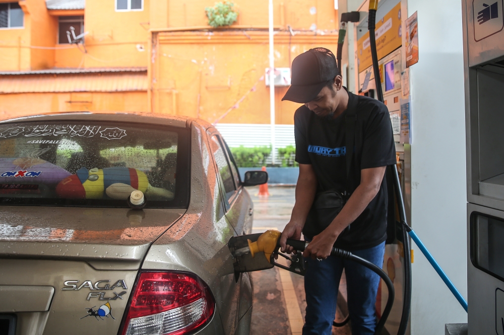 STR recipient Nazarudin Abdul Manap filling up his car under the new Budi Madani RON95 (BUDI95) initiative programme. — Picture by Yusof Isa