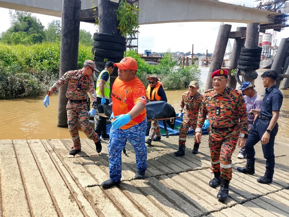 The SAR team carry a victim’s body from the boat into a police truck. — The Borneo Post pic 