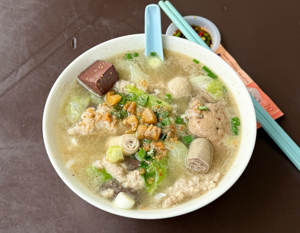 Glorious bowl of hot broth blanketed with goodies like sliced pork, pork patty, coagulated pork blood cubes, intestine and liver. — Picture by Lee Khang Yi
