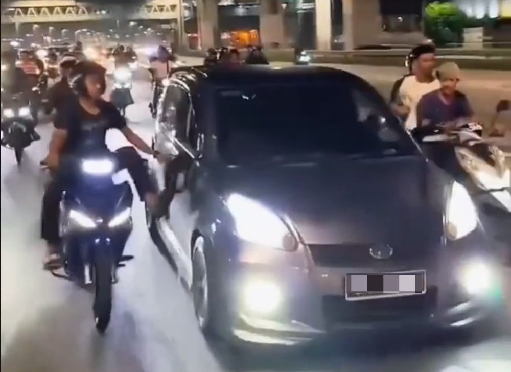 A screen grab shows a motorcyclist kicking at a Perodua Myvi in Puchong.