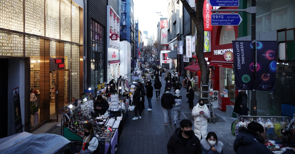 Street vendors (L) wait for customers at Myeongdong shopping district in Seoul, South Korea, January 9, 2023. — Reuters