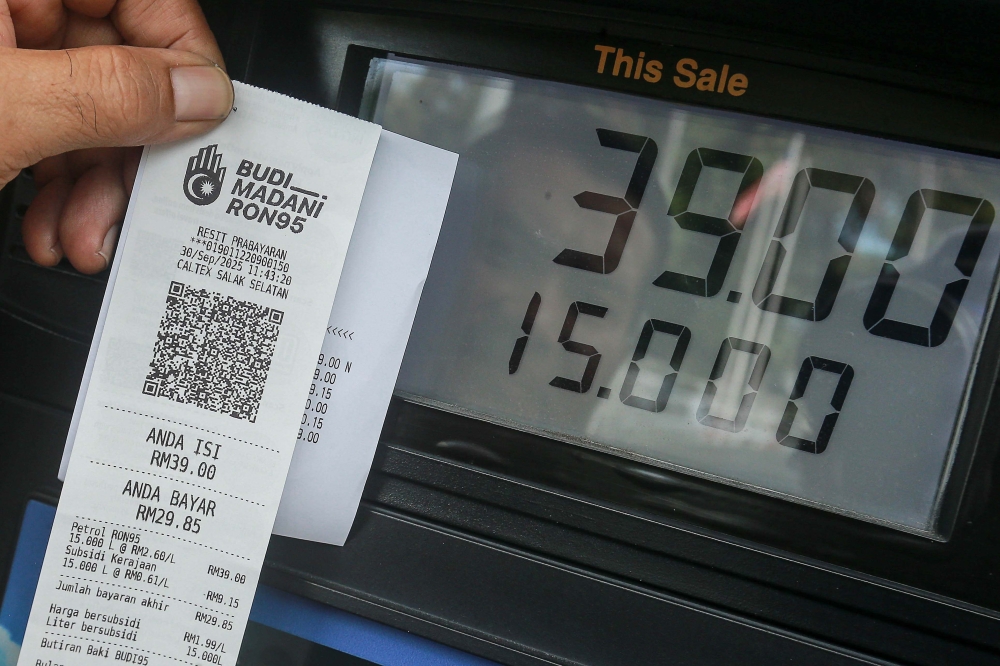 A customer shows the price difference between subsidised and unsubsidised petrol on his receipt after refueling on September 30, 2025. — Picture by Sayuti Zainudin