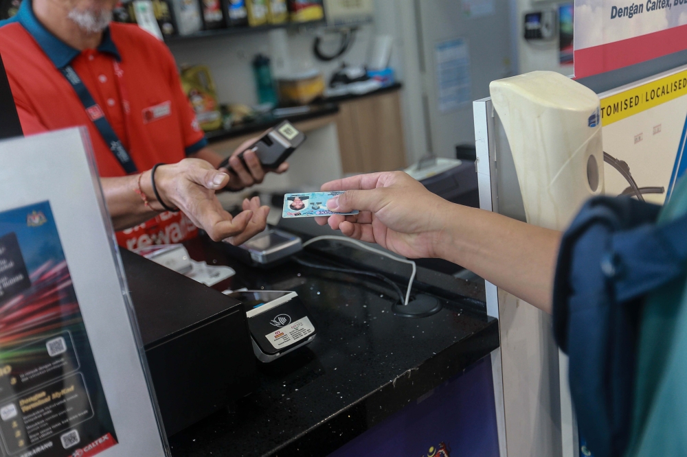 A cashier validates a customer’s MyKad at a petrol station on September 30, 2025, as part of the new Budi95 targeted subsidy initiative. — Picture by Sayuti Zainudin