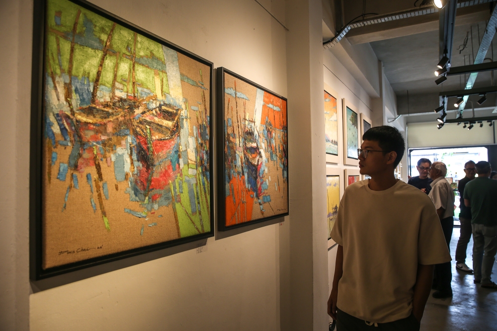 The paintings, depicting the scenery of boats and stilted wooden homes of the Bajau Laut people in Semporna, were created on gunny sacks. — Picture by Yusof Mat Isa