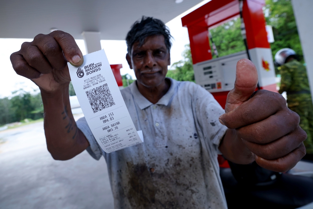 Rubber tapper Rajindran Muniandi gestures after refueling with the subsidised BUDI MADANI RON95 (BUDI95) petrol at a station in Alor Gajah on October 1, 2025. — Bernama pic