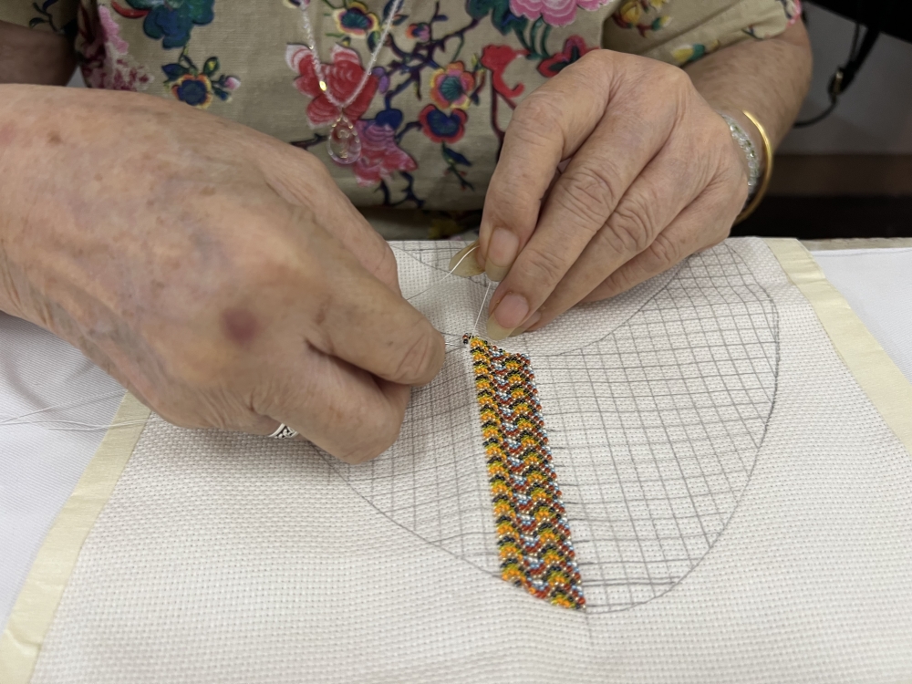 May Lim sews beads onto the cloth. — Picture by Opalyn Mok