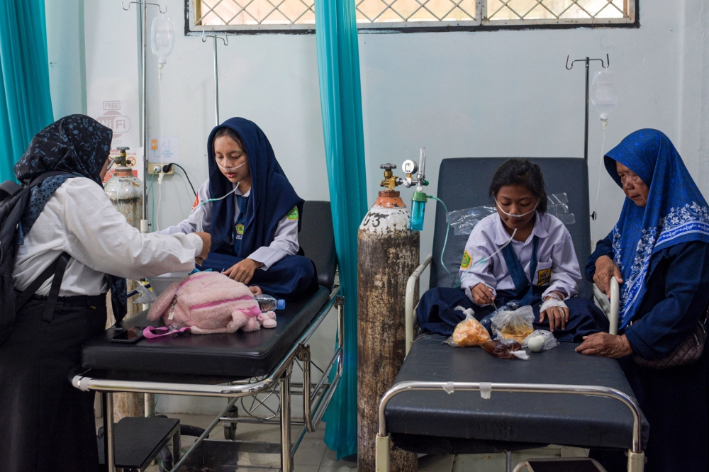 Students who suffering from food poisoning after eating a meal from the government's free meal programme receive treatment at the Kadungora Public Health Centre in Garut. — AFP pic