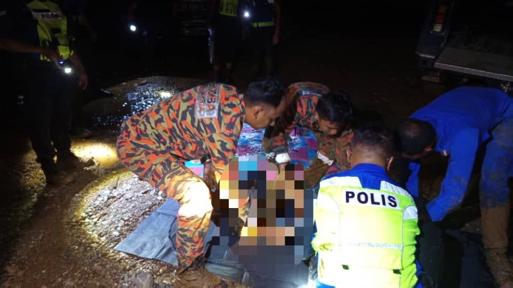 The bodies of mother and son found after they were swept away in a flash flood at Kampung Bangkulut, Tongod, Kinabatangan. — The Borneo Post pic