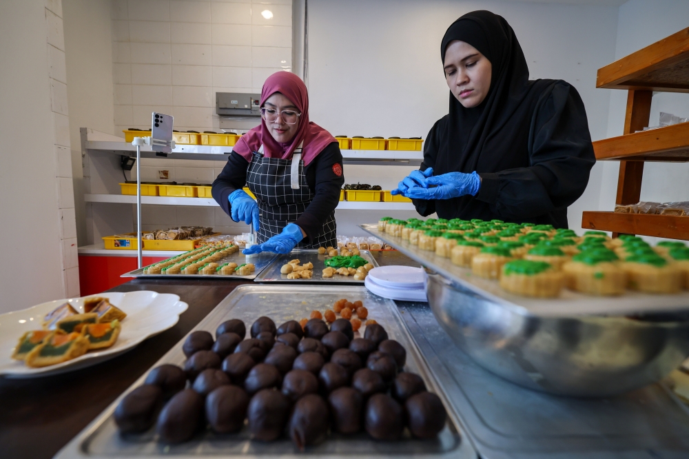 Entrepreneur Nur Farrah Diba Azhar (left) with her sister Nur Shatirah Azhar making moon cakes in conjunction with the Mid-Autumn Festival celebration at her shop near Bandar Perda in Bukit Mertajam October 4, 2025. — Bernama pic