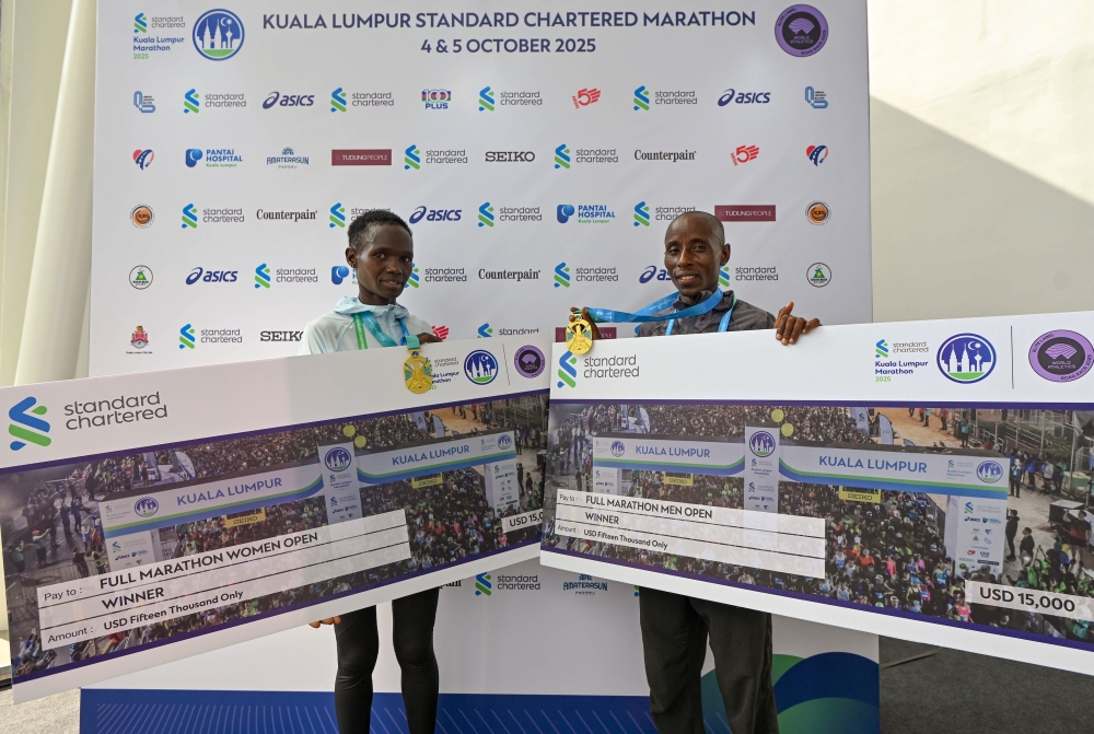 Full Marathon Open category winners John Nzau Mwangangi (right) and Truphena Chepchirchir pose together after completing the Kuala Lumpur Standard Chartered Marathon 2025 in Kuala Lumpur October 5, 2025. — Bernama pic