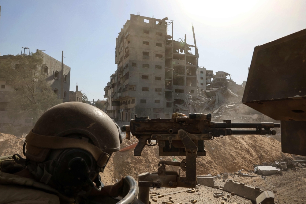 This picture taken during a media tour organised by the Israeli army on October 3, 2025, shows an Israeli army soldier behind a mounted machine gun in the vicinity of the Jordanian Field Hospital in Gaza City. — Jack Guez/Pool/AFP pic 