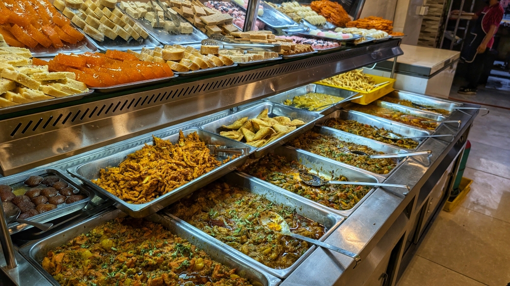 Inside the first shop is a wide selection of meat and vegetable curries, sweets, fried snacks and rice dishes too. — Picture by Ethan Lau