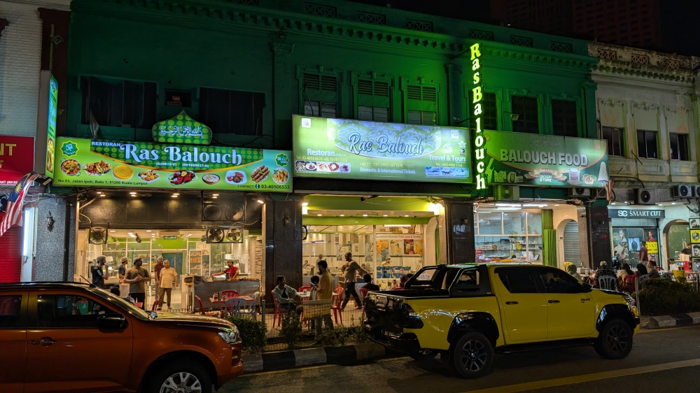 Ras Balouch is easy to spot at night, a verdant green standing out amongst the other shop lots. — Picture by Ethan Lau