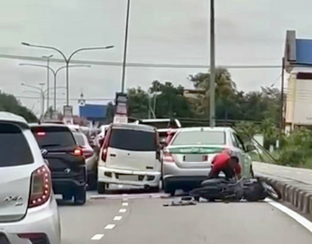 A screenshot from the viral video shows the Kenari trying to squeeze its way through traffic after knocking down the motorcyclist at Jalan Oya in Sibu. — The Borneo Post pic