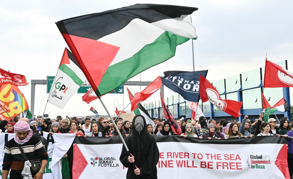 A Pro-Palestinian demonstrator waves a Palestinian flag during the protest on the Milan's highway against the interception by Israeli army of the Global Sumud Flotilla October 3, 2025. — AFP pic 