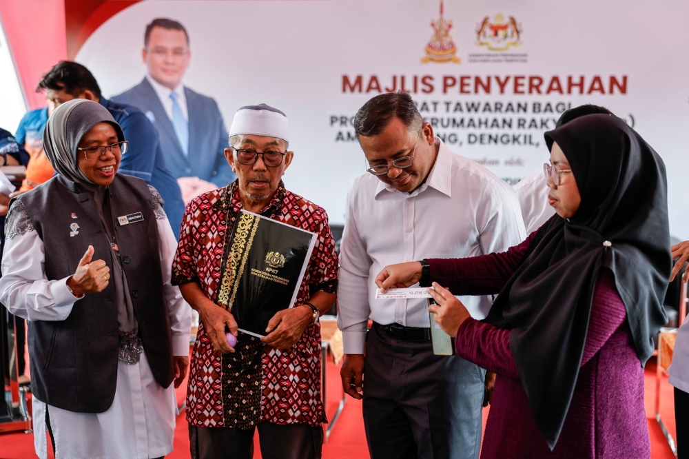 Selangor Menteri Besar Datuk Seri Amirudin Shari observes as one of the recipients, Amat Sadikin Ponidin (2nd left), draws a lot during the Offer Letter Handover Ceremony for the Ampar Tenang People’s Housing Project (PPR) in Dengkil at the Ampar Tenang PPR Community Hall in Sepang, October 6, 2025. Also present was Deputy Minister of Housing and Local Government, Datuk Aiman Athirah Sabu (left). — Bernama pic 
