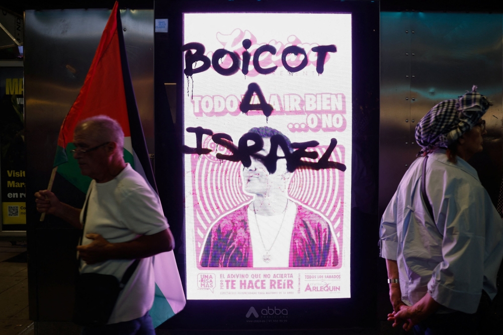 A view of graffiti on a digital advertisement during a demonstration in support of Palestinians and to condemn Israeli forces’ interception of the Global Sumud Flotilla vessels, which were aiming to reach Gaza and break Israel’s naval blockade, in Madrid October 4, 2025. — Reuters pic