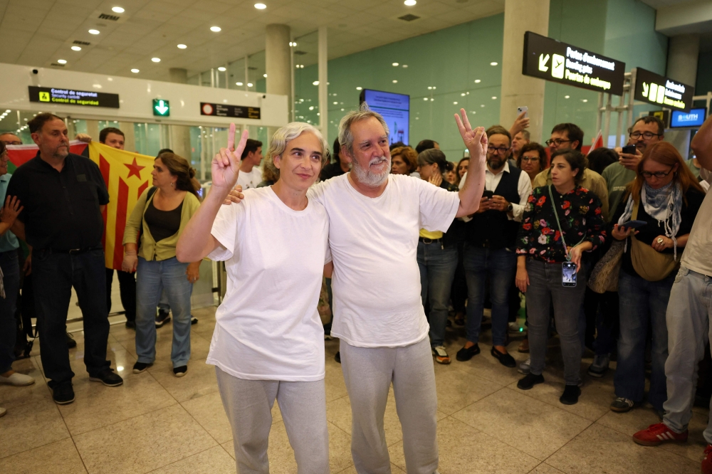 Former Barcelona mayor Ada Colau and Jordi Coronas of Catalan separatist party Esquerra Republicana de Catalunya - ERC, who were sailing aboard vessels from the Global Sumud Flotilla celebrate as they arrive at Barcelona Airport on October 5, 2025, after Israel stopped the Gaza-bound aid flotilla and detained hundreds of people. Spain said 21 of 49 citizens detained on a Gaza aid flotilla were due to leave Israel for home yesterday. — AFP pic 