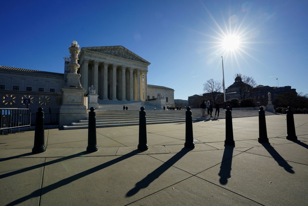 The sun casts shadows as it rises over the US Supreme Court in Washington December 20, 2023. — Reuters pic