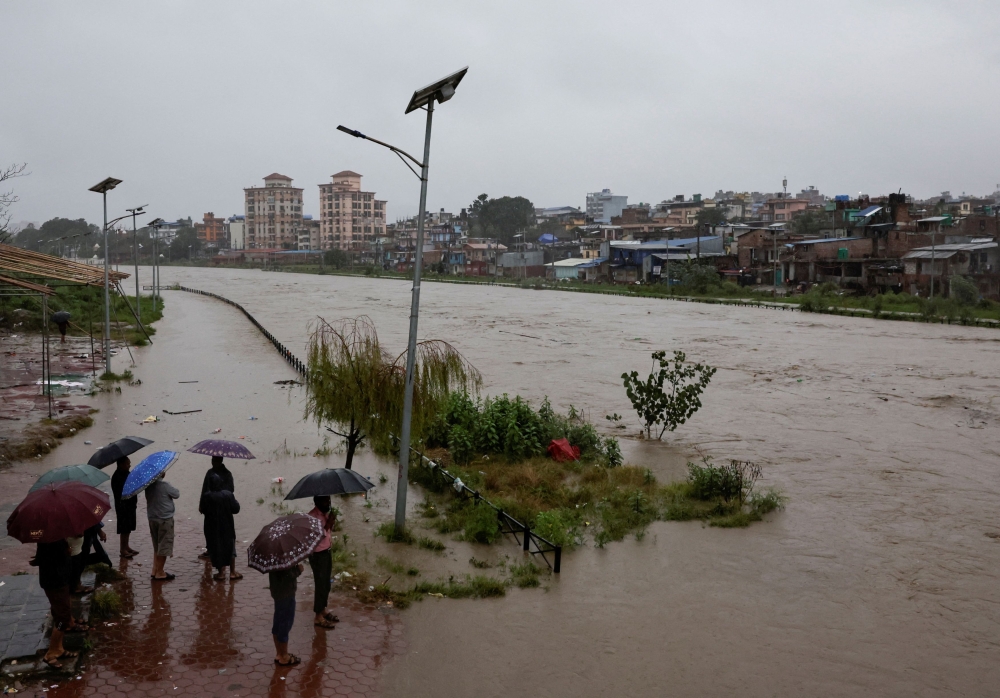 People look towards the overflowing Bagmati River following heavy rains, in Kathmandu October 4, 2025. — Reuters pic