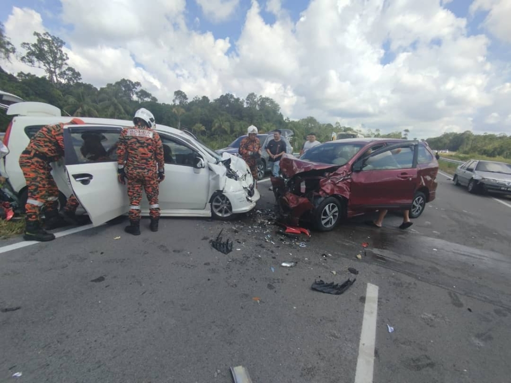 Emergency responders at the scene of the multi-vehicle crash along the new Jalan Samarahan–Stutong Baru bypass, where a motorcyclist was killed and seven others were injured. — The Borneo Post pic
