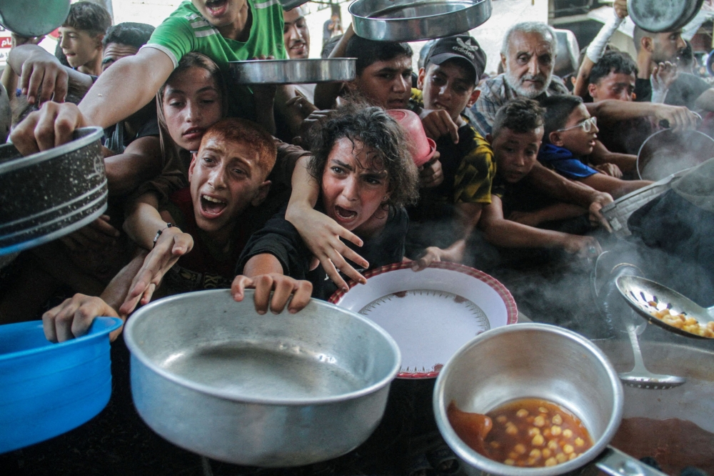 Palestinians gather to receive food cooked by a charity kitchen, amid the Israel-Hamas conflict, in the northern Gaza Strip, September 11, 2024. — File pic via Reuters 