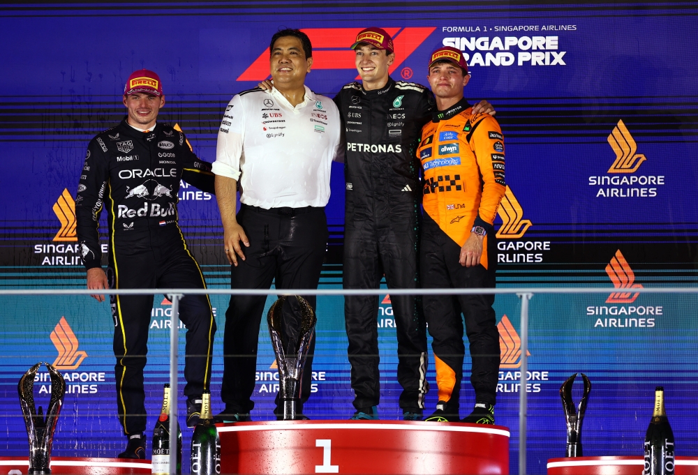 Mercedes’ George Russell celebrates on the podium after winning the Singapore Grand Prix on October 5, 2025, alongside second-placed Red Bull’s Max Verstappen, third-placed McLaren’s Lando Norris, and Petronas president and group CEO Tan Sri Tengku Muhammad Taufik. — Reuters pic