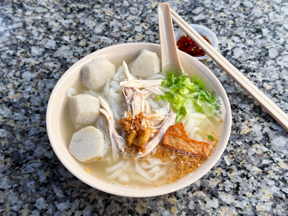 Comforting flavours are packed into this bowl of ‘kuey teow thng’ with ‘saito’ fish balls, shredded chicken, fried fish cake and rice noodles. — Picture by Lee Khang Yi