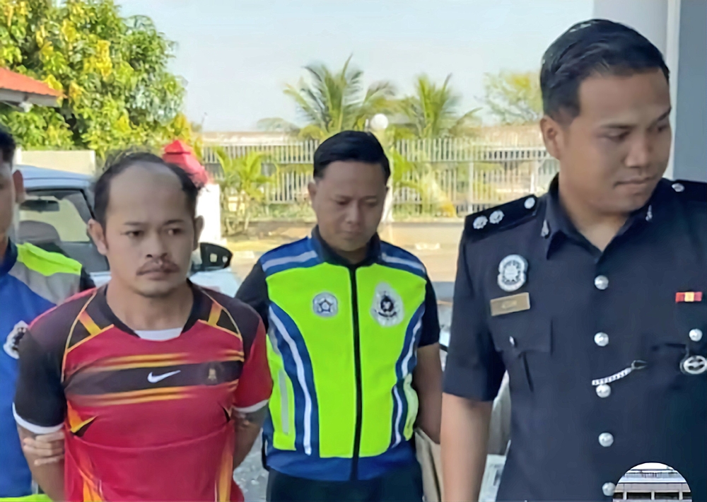 Police bring Umpang to the cafe for the crime scene reconstruction. — Police pic