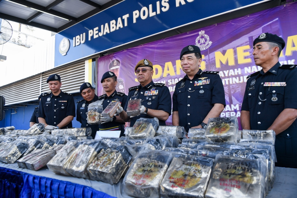 Perak police chief Datuk Noor Hisam Nordin (3rd right) and his officers show part of the 374kg of methamphetamine and 11.28kg of heroin worth about RM12.9 million seized from a vehicle at KM 375 of the southbound North–South Expressway near Slim River, Tanjung Malim, on Monday, during a press conference at the Perak Police Headquarters in Ipoh October 8, 2025. — Bernama pic