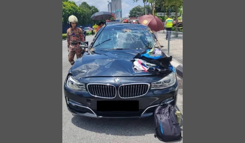 Fire and rescue personnel at the scene after a tree fell on a BMW along Jalan Tun Razak in Kuala Lumpur this afternoon. — Bomba pic