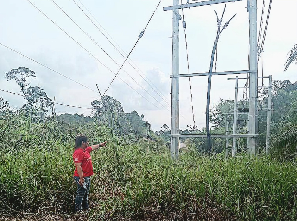 An engineer shows where the underground cable was cut. — Police photo via The Borneo Post 