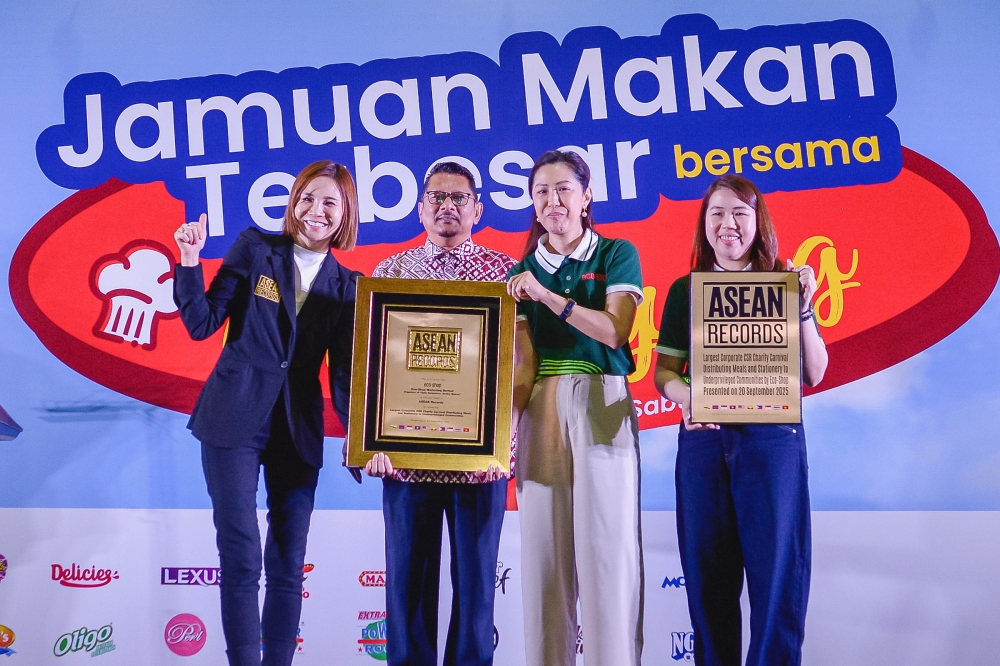 Eco-Shop Marketing Berhad chief executive officer and executive director Jessica Ng (second, right) pose for a photo while receiving the Asean Record certificate from Asean Records managing director Gilian Goh (left) at the Eco-Shop Grand Feast with Che Sayang. — Bernama pic 